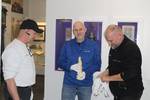 Museologe André Pohl (Mitte) mit der Bischofsfigur zwischen den Fachleuten von DB Schenker