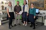 Dr. Antje J. Gornig, Dr. Claudia Brandt und Kristin Houschka übergeben den Zwischenbericht an an Mathias Deinert vom DZK.